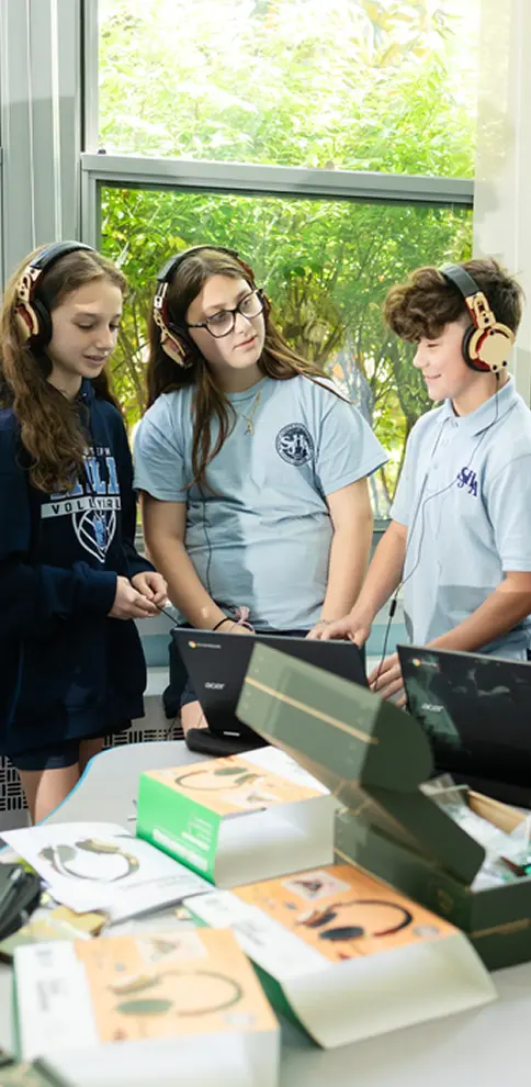 Group of students listening to music using headphones from a KiwiCo STEAM classroom project.
