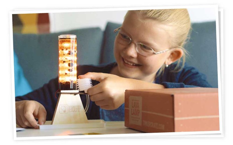 Happy child with diy lava lamp from Tinker Crate monthly STEM kit