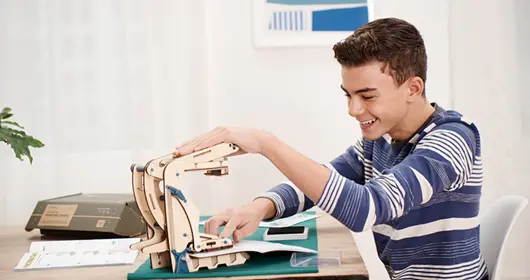 Young engineer shining a 2-in-1 Lantern from a Eureka Crate.