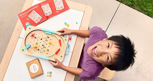 Young engineer aiming a bow from a Kiwi Crate Archery Set at a target.